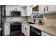 Features a sink with white cabinets, stainless appliances, and chevron backsplash at 9391 W Hialeah Pl, Littleton, CO 80123