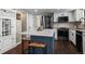 Lovely kitchen island with stainless appliances, white cabinets, and tile backsplash at 9391 W Hialeah Pl, Littleton, CO 80123