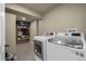 Bright laundry room with modern washer and dryer and shelving for organized storage at 9391 W Hialeah Pl, Littleton, CO 80123
