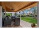 Inviting covered outdoor living area with comfortable seating, ceiling fan, and lush backyard view at 9391 W Hialeah Pl, Littleton, CO 80123