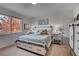 Bright bedroom with a large window offering tree views, plush bedding, and ample storage at 10380 W 55Th Ln # 204, Arvada, CO 80002