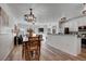 Open-concept dining room with hardwood floors, a rustic chandelier, and access to the kitchen and living room at 10380 W 55Th Ln # 204, Arvada, CO 80002