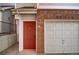 Close-up of the red front door with a decorative door knocker, next to the garage door at 10380 W 55Th Ln # 204, Arvada, CO 80002