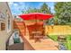Outdoor patio with wood flooring, furniture, red umbrella, and wooden fence is great for relaxing at 12433 Bellaire Dr, Thornton, CO 80241