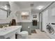 Updated bathroom features vanity, round mirror, and washer and dryer at 12433 Bellaire Dr, Thornton, CO 80241