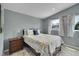 Comfortable bedroom with a patterned quilt, neutral walls, and a bright window at 12433 Bellaire Dr, Thornton, CO 80241
