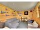 Bonus room with wood paneled walls, sports decor, and comfortable seating at 12433 Bellaire Dr, Thornton, CO 80241