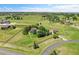 Wide aerial view of a home with fenced-in acreage and mature trees, backing to green pastures and neighborhood at 25741 E Kettle Cir, Aurora, CO 80016