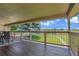 Covered porch with wood floors and railing offering picturesque views of the green lawn at 25741 E Kettle Cir, Aurora, CO 80016