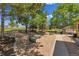 Serene backyard space with mature trees, stone ground cover, and multiple seating areas for outdoor enjoyment at 25741 E Kettle Cir, Aurora, CO 80016