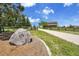 Property entrance featuring a rock with address and a tree-lined driveway leading to the home at 25741 E Kettle Cir, Aurora, CO 80016