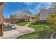 Serene backyard with a patio seating area, manicured lawn, blooming trees, and a brick pathway at 1230 S Emerson St Dr, Denver, CO 80210