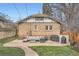 A brick patio with outdoor seating and a grill, surrounded by lush greenery and mature trees at 1230 S Emerson St Dr, Denver, CO 80210