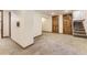 Finished basement area with carpeted floors and access to the stairs at 1230 S Emerson St Dr, Denver, CO 80210