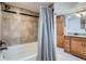 Updated bathroom with a tiled shower, tub, modern fixtures, and a stylish vanity with ample storage at 1230 S Emerson St Dr, Denver, CO 80210