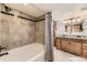 Tiled bathroom with a bathtub and shower, double sinks with granite counters, and modern fixtures at 1230 S Emerson St Dr, Denver, CO 80210