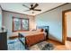 Cozy bedroom with hardwood floors, a ceiling fan, and a large window for natural light at 1230 S Emerson St Dr, Denver, CO 80210