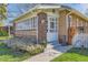 Charming brick home features a white-framed glass door and sunroom with a well-manicured lawn at 1230 S Emerson St Dr, Denver, CO 80210