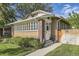 Brick home's inviting entrance, featuring a charming white door, well-maintained lawn, and a quaint wooden fence at 1230 S Emerson St Dr, Denver, CO 80210
