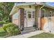 A welcoming front entrance to a brick home with a multi-paned door and manicured landscaping at 1230 S Emerson St Dr, Denver, CO 80210
