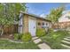Detached garage with brick exterior, white door, landscaping, and a fenced yard at 1230 S Emerson St Dr, Denver, CO 80210