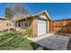A single-car brick garage with a white door, concrete driveway, and well-kept landscaping at 1230 S Emerson St Dr, Denver, CO 80210