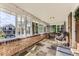 Inviting brick porch with slate flooring, comfortable seating, and bright, airy windows showcasing the outdoor scenery at 1230 S Emerson St Dr, Denver, CO 80210