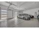 Spacious three-car garage with modern cars, ample lighting, and epoxy flooring at 10095 S Shadow Hill Dr, Lone Tree, CO 80124