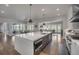 Spacious kitchen features an island with seating, pendant lights, a stainless steel dishwasher, and views of the living room at 10095 S Shadow Hill Dr, Lone Tree, CO 80124