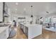 Modern kitchen features a stainless steel vent hood, white cabinetry, and a large kitchen island with a sink and stainless steel dishwasher at 10095 S Shadow Hill Dr, Lone Tree, CO 80124