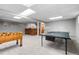 Spacious finished basement featuring a foosball table, a ping pong table, and a bar at 1513 S Beech St, Lakewood, CO 80228