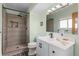 Updated bathroom featuring a wood look shower with black fixtures, updated vanity, and a window for natural light at 1513 S Beech St, Lakewood, CO 80228