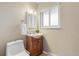 Well-lit bathroom features a wood vanity, frosted window, and white fixtures at 1513 S Beech St, Lakewood, CO 80228