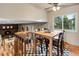 Bright dining area features wood floors, a window with natural light, and a view of the living room and fireplace at 1513 S Beech St, Lakewood, CO 80228