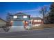 Two-story home features brick accents, an attached garage, and a well-maintained front yard at 1513 S Beech St, Lakewood, CO 80228