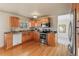 Bright kitchen featuring wood cabinetry, stainless steel appliances, and hardwood floors at 1513 S Beech St, Lakewood, CO 80228