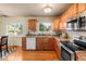 Bright kitchen featuring wood cabinetry, granite countertops, and stainless steel appliances at 1513 S Beech St, Lakewood, CO 80228