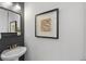 Stylish powder room with a modern vanity, decorative mirror, and unique wall art at 1625 King St # 4, Denver, CO 80204