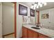 Bathroom featuring granite countertops, wood cabinetry, and a decorative mirror at 6279 Cheyenne Ct, Parker, CO 80134