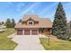 Inviting two-story home with a three-car garage and charming front porch surrounded by lush greenery at 6279 Cheyenne Ct, Parker, CO 80134