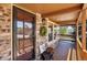 Cozy covered porch featuring brick accents, a decorative wreath, and comfortable seating at 6279 Cheyenne Ct, Parker, CO 80134