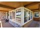 Covered porch with large windows, brick accents, and inviting outdoor seating at 6279 Cheyenne Ct, Parker, CO 80134
