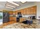 Kitchen featuring oak cabinets, granite countertops, black appliances and decorative ceiling panels at 6279 Cheyenne Ct, Parker, CO 80134