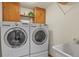 A functional laundry room is equipped with front loading washer and dryer and practical storage cabinets at 6279 Cheyenne Ct, Parker, CO 80134