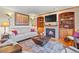 Inviting living room featuring hardwood floors, a fireplace, and built-in bookshelves at 6279 Cheyenne Ct, Parker, CO 80134