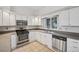 Clean white kitchen with stainless steel appliances, tile floors, and a bright window at 723 Eaton Rd, Palmer Lake, CO 80133