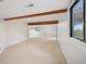 Large living room with exposed beams, neutral carpet, a window, and a sliding glass door at 723 Eaton Rd, Palmer Lake, CO 80133