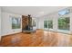 Spacious living room with hardwood floors, a stone fireplace, and doors to a balcony at 723 Eaton Rd, Palmer Lake, CO 80133