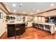 Basement bar featuring a dark wood bar, granite countertop, seating, and decorative shelving at 479 Blue Lake Trl, Lafayette, CO 80026