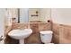 Half bathroom featuring tile backsplash, a pedestal sink, and a clean, modern design at 479 Blue Lake Trl, Lafayette, CO 80026